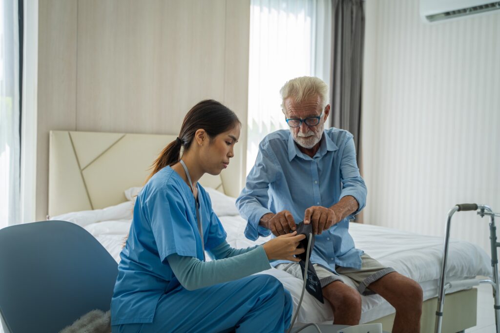 Nurse taking care of senior man patient at home.